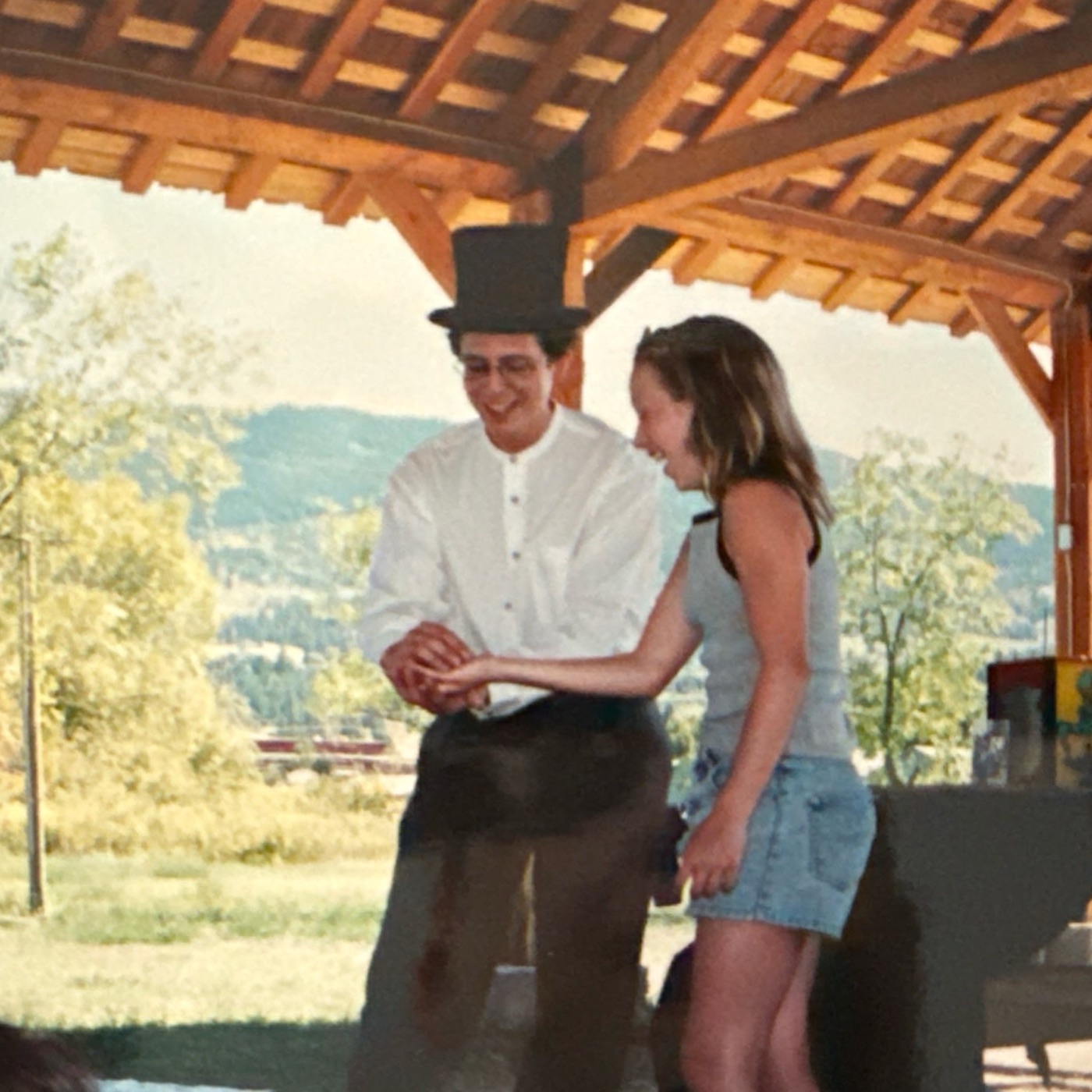 Years ago: Daniel in a top hat, performing a trick for a laughing volunteer